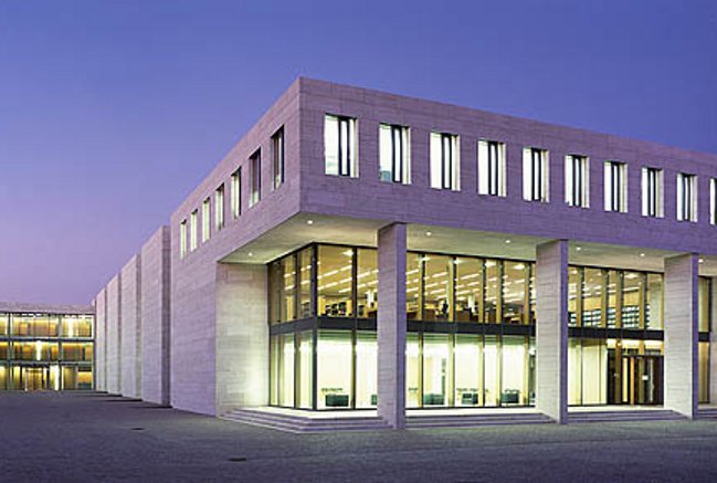 Blick bei Dunkelheit auf das erleuchtete Bibliotheksgebäude